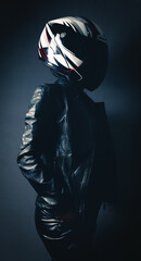 girl with leather clothes stands and poses in her head with a motorcycle helmet