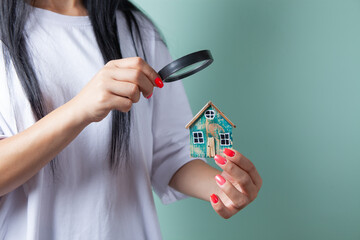 woman looking at the house with a magnifying glass