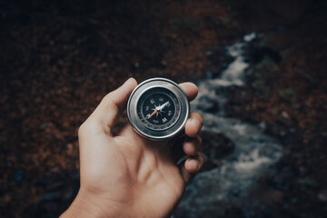 holding a compass on the background of nature