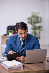 Young male employee unhappy with excessive work in the office