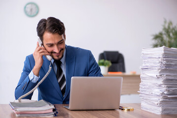 Young male employee unhappy with excessive work in the office