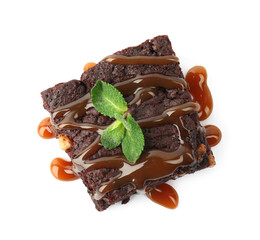 Delicious chocolate brownies with nuts, caramel sauce and fresh mint on white background, top view