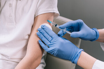 Vaccination of children. Woman doctor makes injection to teenage girl. Close up of hands.