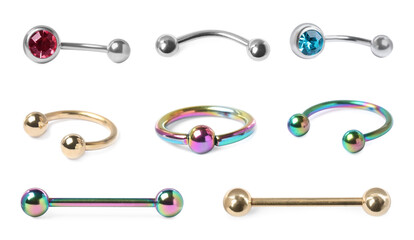 Set with different piercing jewelry on white background