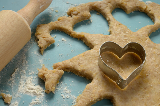 Heart-shaped cookie cutter on dough - Powered by Adobe