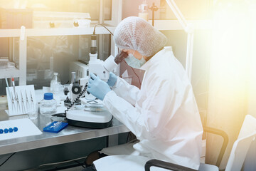 Medic or scientist looking through a microscope in a scientific medical laboratory. Biochemical...