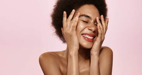 Spa and beauty. African american girl showering, cleansing her healthy natural skin with facial toner, splash of smth on face, close eyes and smile pleased, standing against pik background