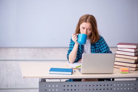 Young female student drinking coffee during break