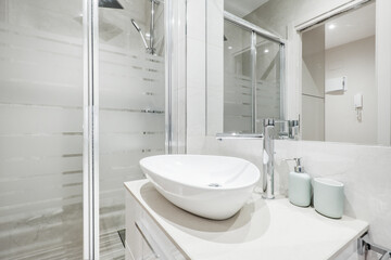 Shell-shaped white porcelain sink with walk-in shower, wall-mounted mirror