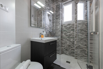 Sink with dark wood cabinet and shower with glass partition and white porcelain sink