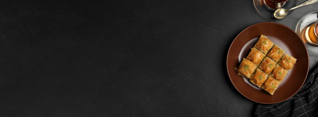 Delicious sweet baklava on black table, flat lay. Space for text