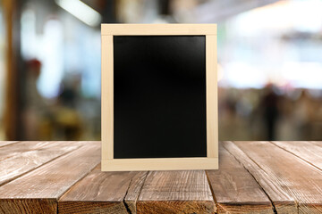 Small blank chalkboard on wooden table indoors. Mockup for design