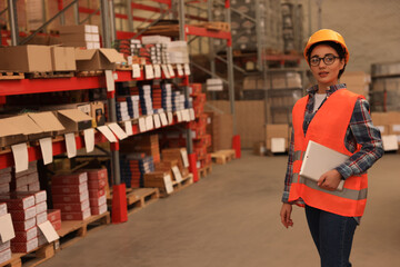 Woman with tablet working at warehouse. Logistics center