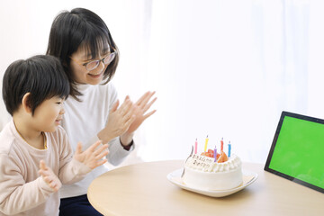 Fototapeta na wymiar モニター越しに誕生日をお祝いするアジア人の家族