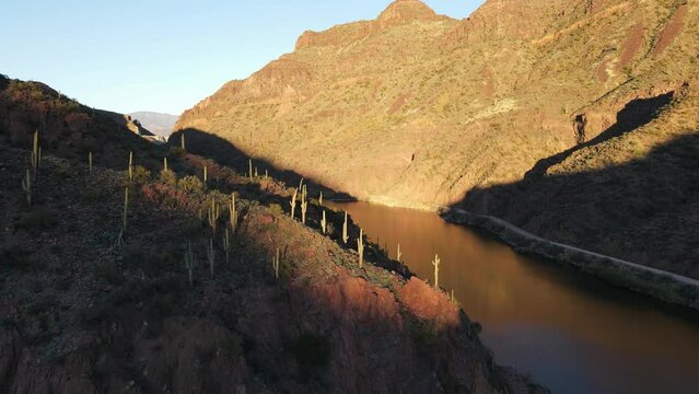 4K Aerial of a Drone Flying over a River in the desert during golden hour showing cactus, mountains and part of a blue sky, Salt River in Roosevelt Lake Arizona, apache trail