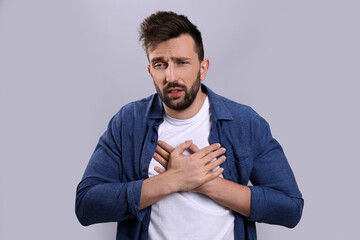 Man suffering from cold on grey background