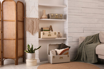 Stylish room interior with comfortable sofa and storage trunks