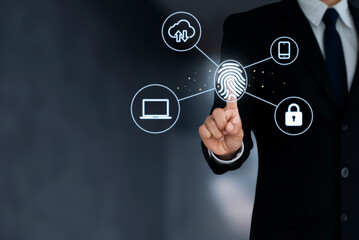 A young businessman wearing a black suit uses his finger and select the icon security to unlock access to laptops, documents and clouds by scanning his fingerprints.