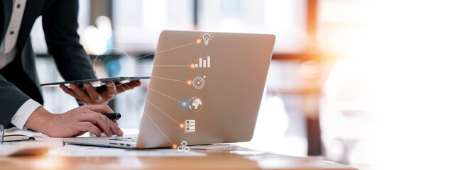 Businessman using laptop computer and digital tablet and icon network connection data customer, digital marketing, financial and payment online, analysis and planning of business strategy.