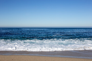Fototapeta na wymiar A view on the Pacific ocean seashore with blue sky