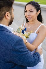 latina bride looking at her newlywed husband. vertical photo