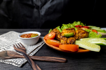 Grilled chicken with soy sauce and garnish with cucumber, tomato, lettuce, and chili