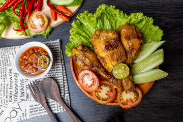 Grilled chicken with soy sauce and garnish with cucumber, tomato, lettuce, and chili