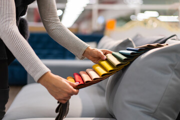 The woman chooses the fabric on the sofa. A young women looks at tissue samples. Selects the color...