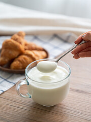 Scoop yogurt from the cup with a spoon in hand