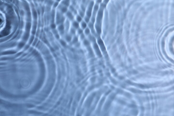 Closeup view of water with rippled surface on blue background