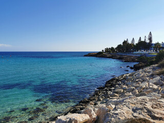 Fototapeta na wymiar Cyprus. Rocky coast, clear water of the Mediterranean Sea against a blue, almost cloudless sky.