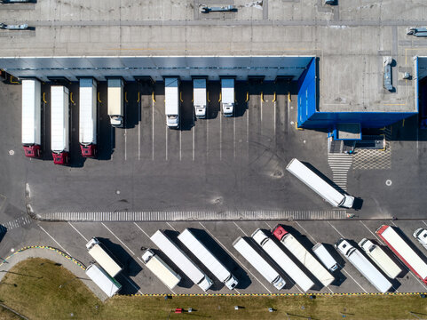 Large lorries at parking area near plant storehouse building