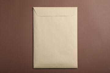 Kraft paper envelope on brown background, top view