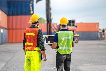 Professional engineer container cargo foreman team in helmets working standing and using walkie talkie checking stock into container for loading.logistic transport and business industry export