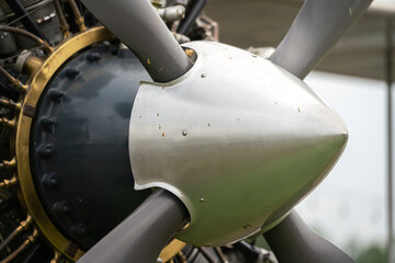 Close-up at historical WWII fighter airplane's propeller cap nose, front of the plane part. Transportation vehicle equipment, selective focus.