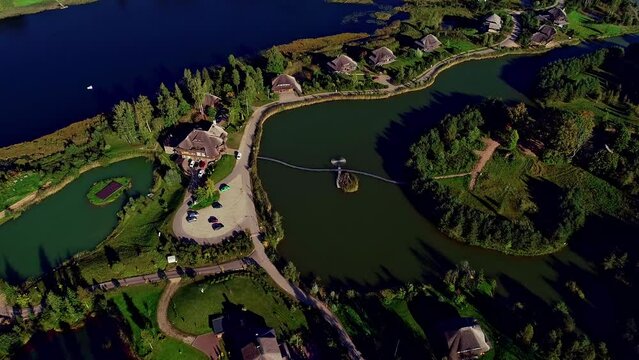 Aerial view of small lakes and typical wooden cabins on the island. Sunlight in the evening by calm water on warm beautiful summer day.