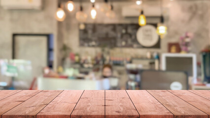 Empty wood table top and blurred coffee shop, cafe and restaurant interior background - can used for display or montage your products.