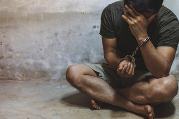 Young man desperate to catch the iron prison, prisoner concept, Handcuffed hands of a prisoner in...