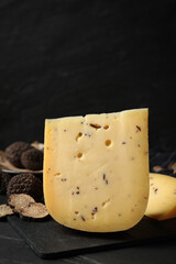 Fresh cheese and truffles on black table