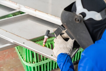 Men's hands with argon welding machine.