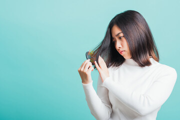 Young beautiful Asian woman upset with a comb and problem hair, Portrait female shocked suffering...