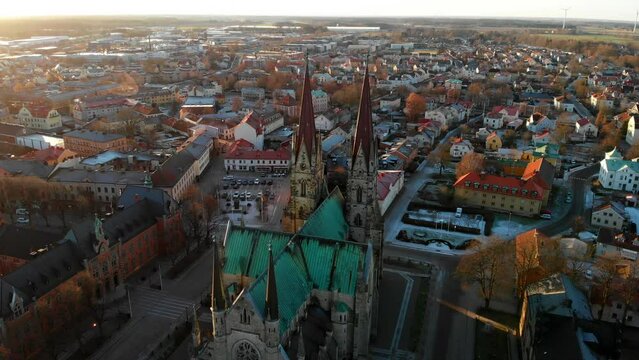 Roof And Spires Of Historic Skara Cathedral In Skara, Sweden At Sunrise. aerial drone orbit