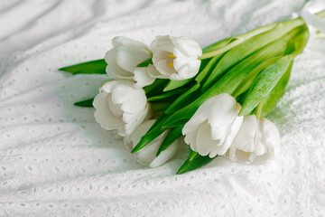 Fototapeta na wymiar White tulips flowers on the white textile background