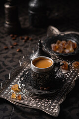 Coffee in metal Turkish traditional cup and coffee beans on dark tile background