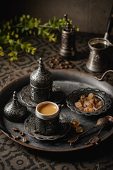 Coffee in metal Turkish traditional cup and coffee beans on dark tile background
