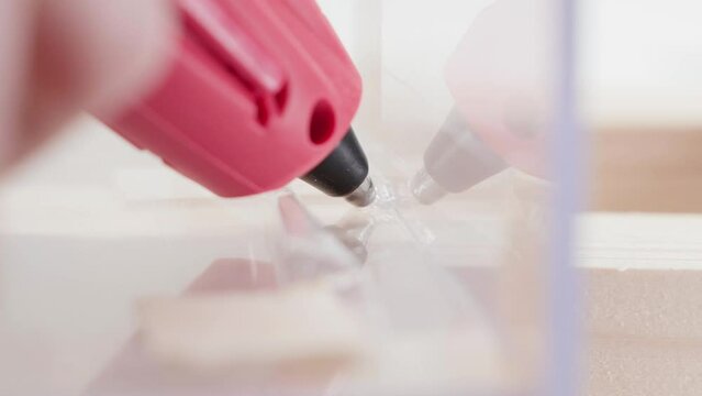Gluing plexiglass with a glue gun close-up