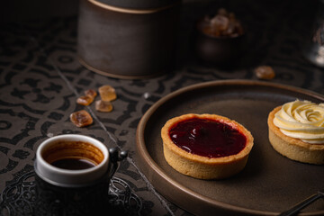 Mini tart with whipped cream cherry and lemon sweet dessert on dark tile background