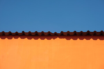Abstract photo of a gray zinc roof with a tangerine orange shade over a very light blue clear sky background. Pop artwork Cityview lifestyle concept ideas. Backdrop design surrealistic contemporary