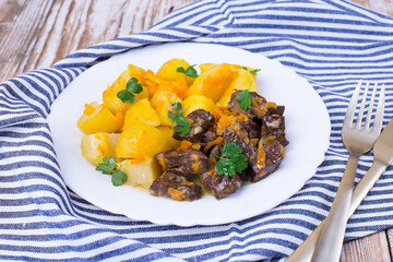 Roast beef liver with potatoes, onions and carrots. Delicious meat dish.