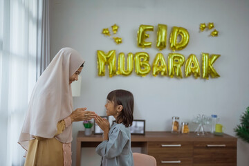 daughter kissing her mother's arm during eid mubarak